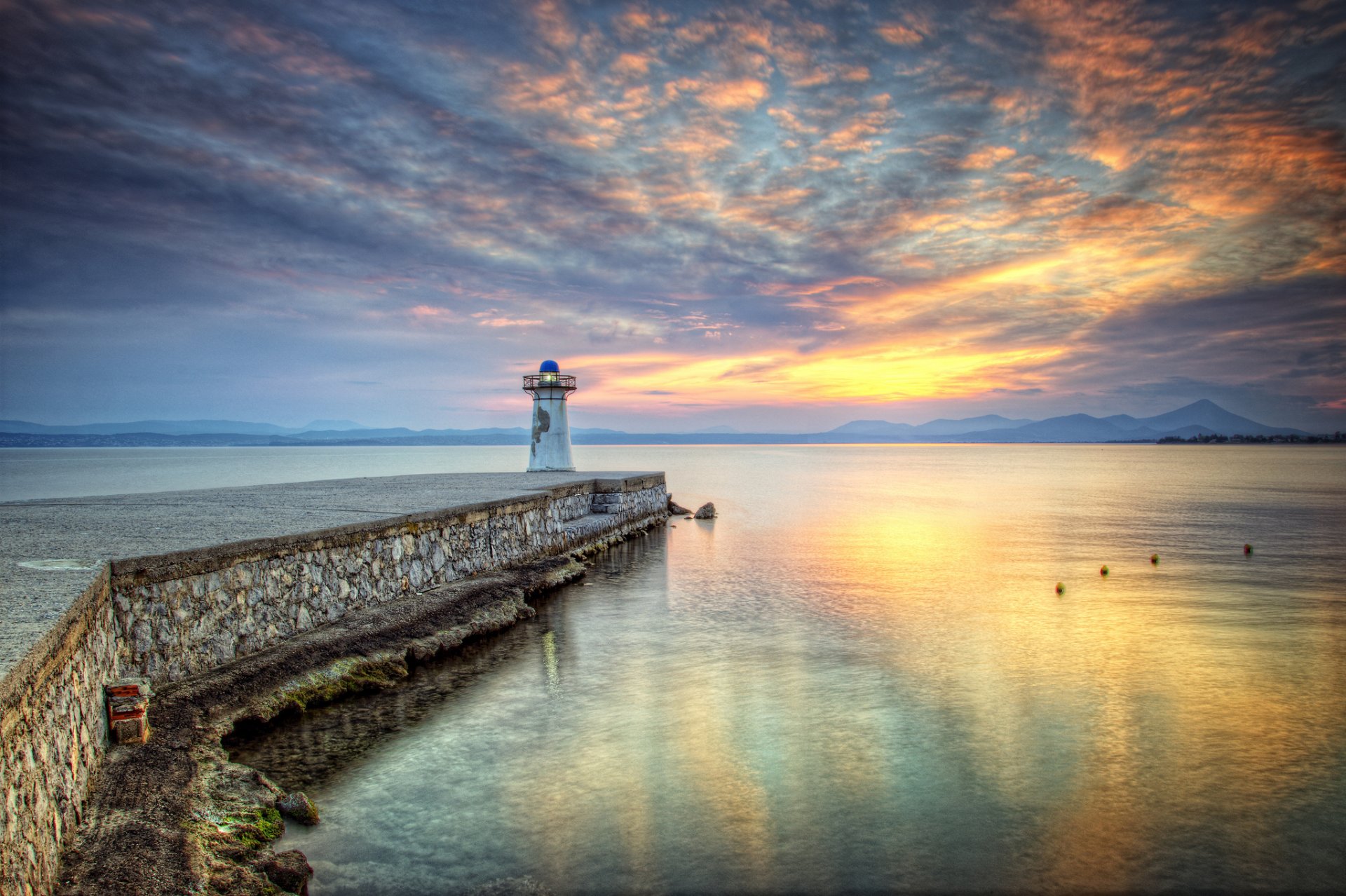 montagnes baie jetée phare coucher de soleil