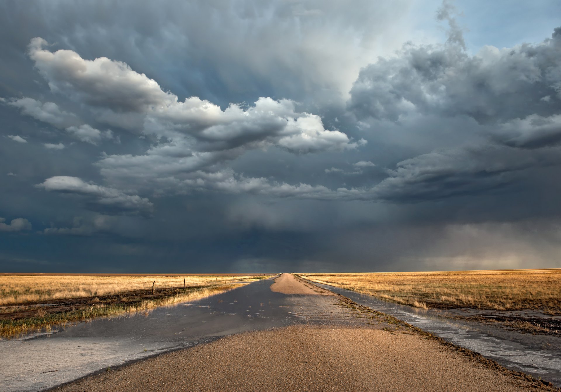 campos carretera charcos nubes después de la lluvia