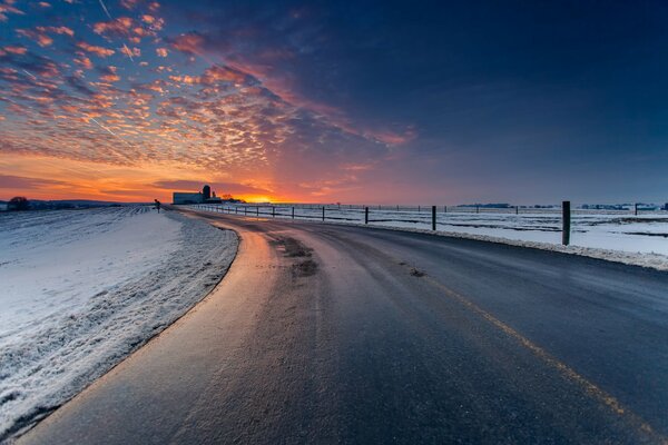 Image of a road in winter and a sunset sky