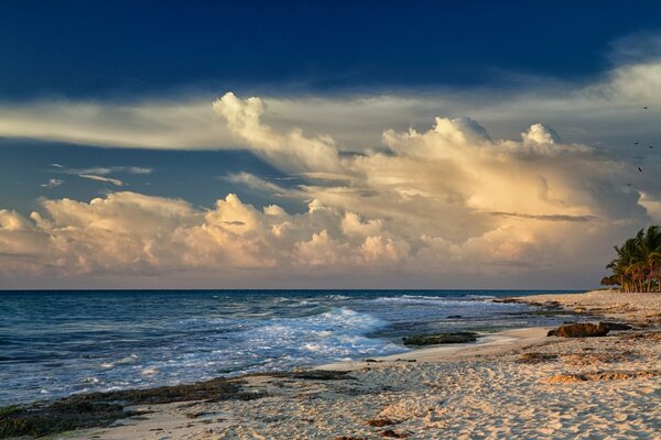 Poruszające morze przy piaszczystej plaży i gęste chmury na niebie