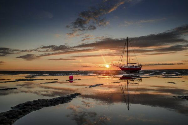 Boat in the sea on the background of sunset