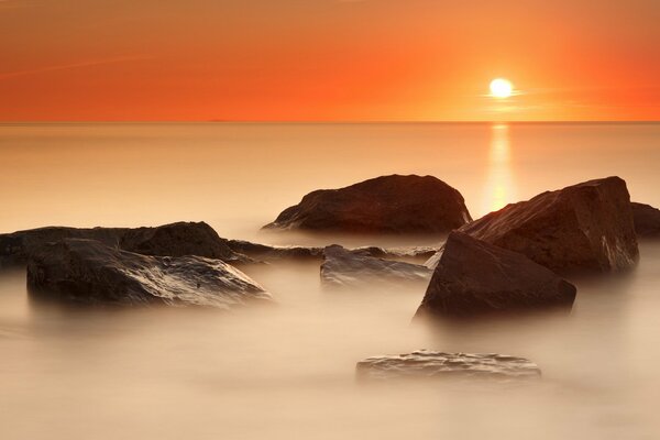 Calma en el mar, cielo naranja