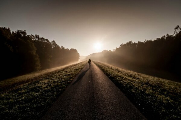 Imagen de un hombre por la mañana en la carretera en la niebla