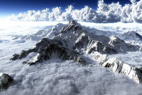 Picos de montaña en la nieve y las nubes