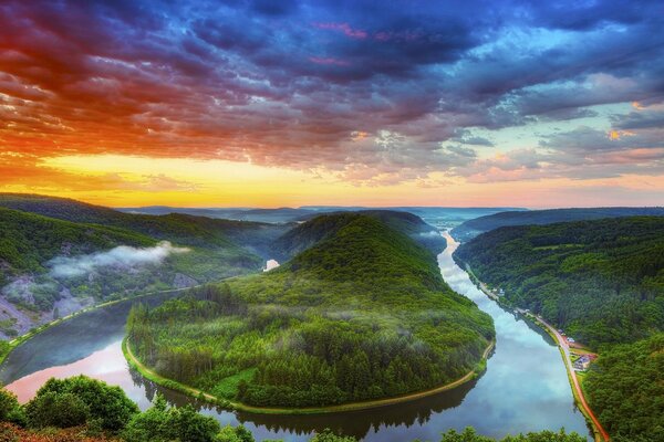 Landschaft von Fluss, Bäumen, Wäldern und Wolken bei Sonnenuntergang