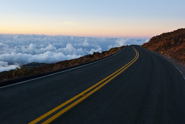 Route passant par les montagnes, laissant dans les nuages planants