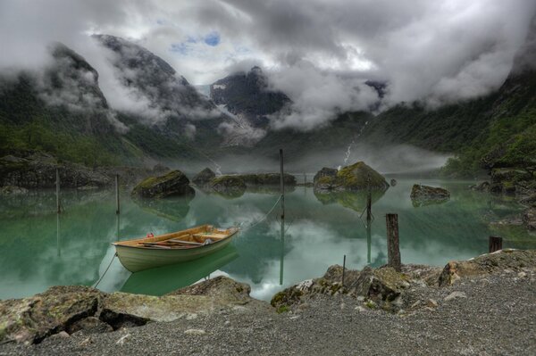 Montagnes norvégiennes à côté du lac sur lequel le brouillard surplombe