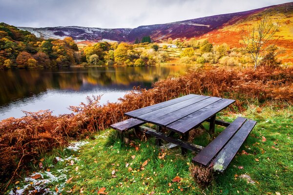 Herbstlandschaft Tisch mit Bänken am Flussufer