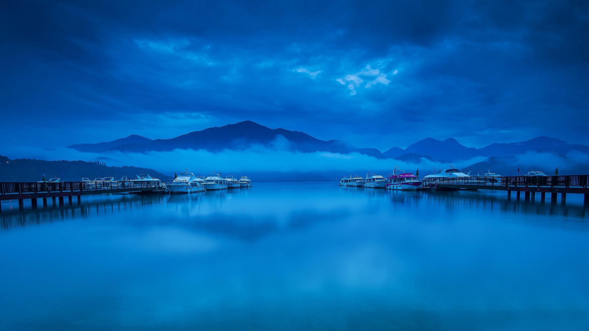 montañas nubes niebla bahía muelle barcos