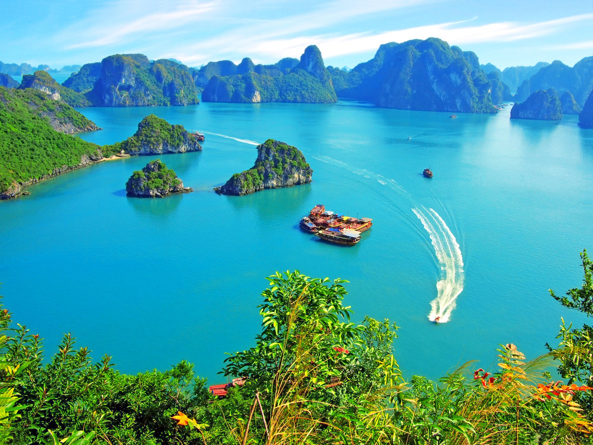 vietnam baia di ha long rocce isole vegetazione barche da diporto yacht giunche cielo nuvole