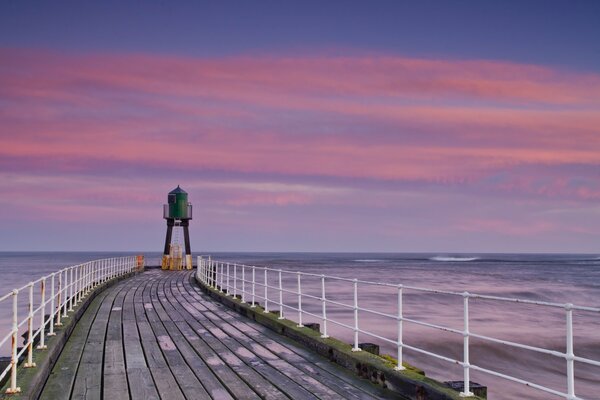 Muelle del mar contra el cielo rosa