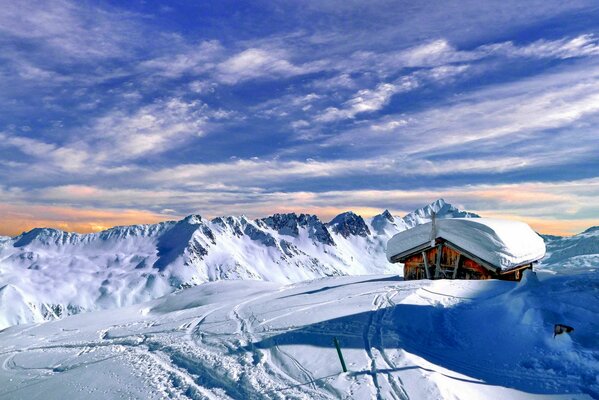 Haus im Schnee vor dem Hintergrund der Wolken