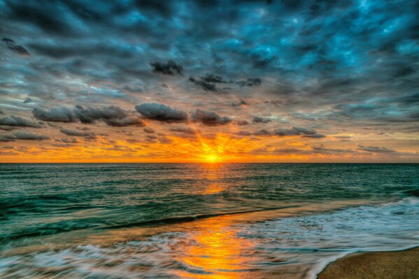 Puesta de sol sobre la playa azul