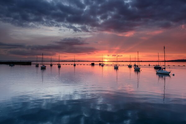 Yachts on the horizon of an orange sunset