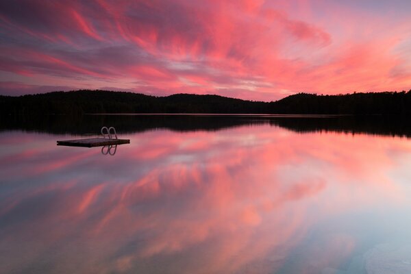 Pink sunset, calm water surface