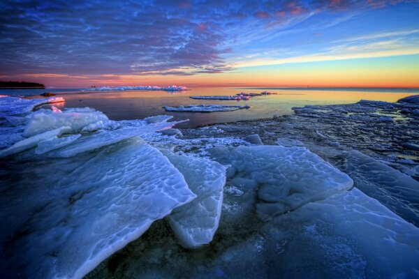 Ice floes on the background of dawn in the sea