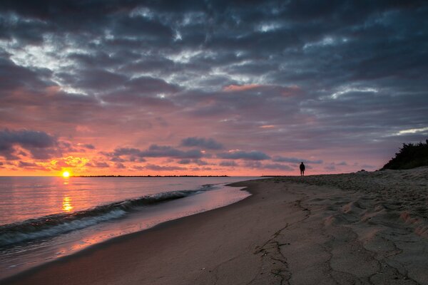 Paseo por la playa de arena durante el amanecer