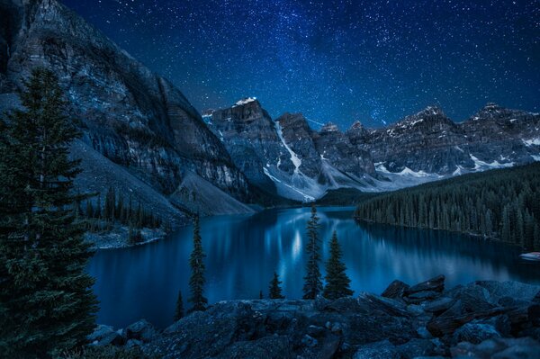 Lago in montagna sotto il cielo stellato notturno
