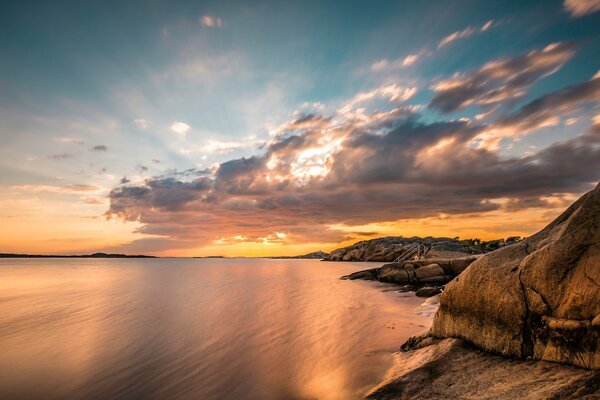 Les rayons du soleil levant se reflètent dans les eaux calmes de la mer