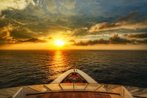 The bow of the ship and the reflection of the sunset in the sea