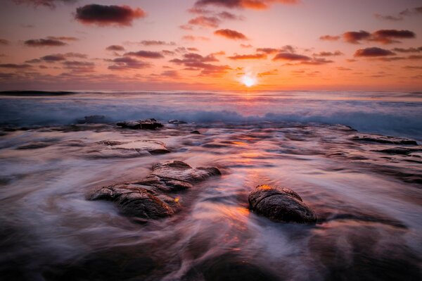 Orange dawn over a rocky shore