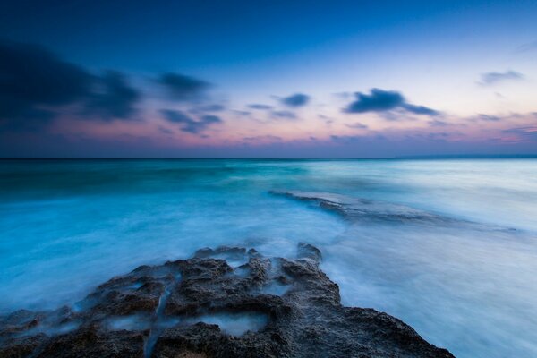 Seestück. Steinstrand und blaue Wolken