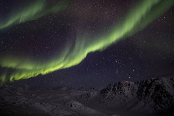 Aurora boreal en las montañas. Una maravilla verde en el cielo