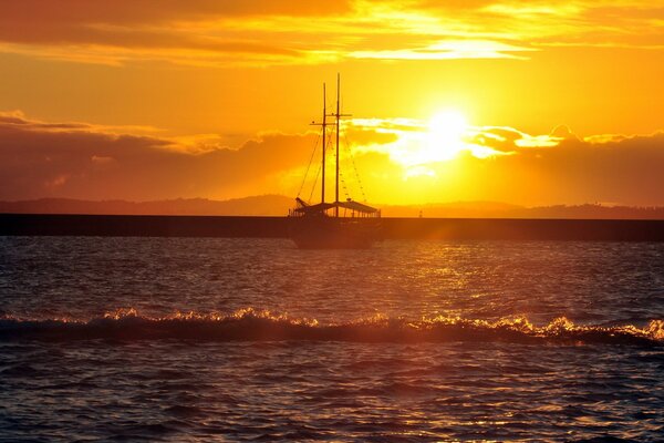 Silhouette eines Schiffes im Meer bei Sonnenuntergang