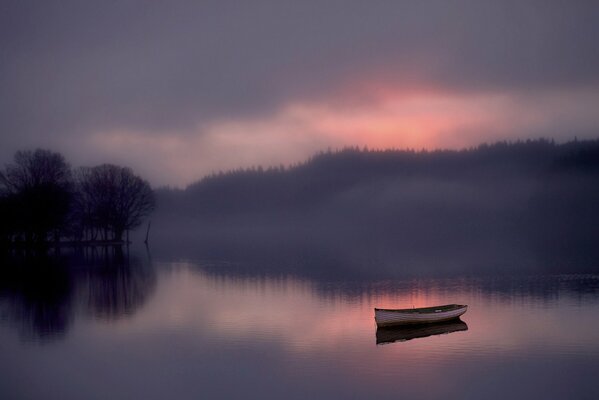 Fog during dawn boat lake