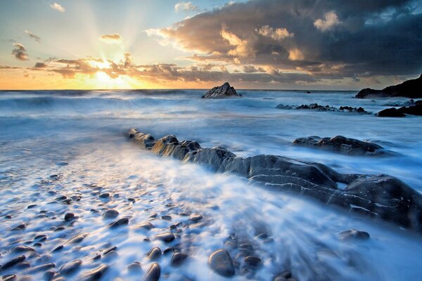 Sunrise and fog covering water rocks and stones