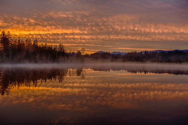 Lac brumeux sur fond de coucher de soleil