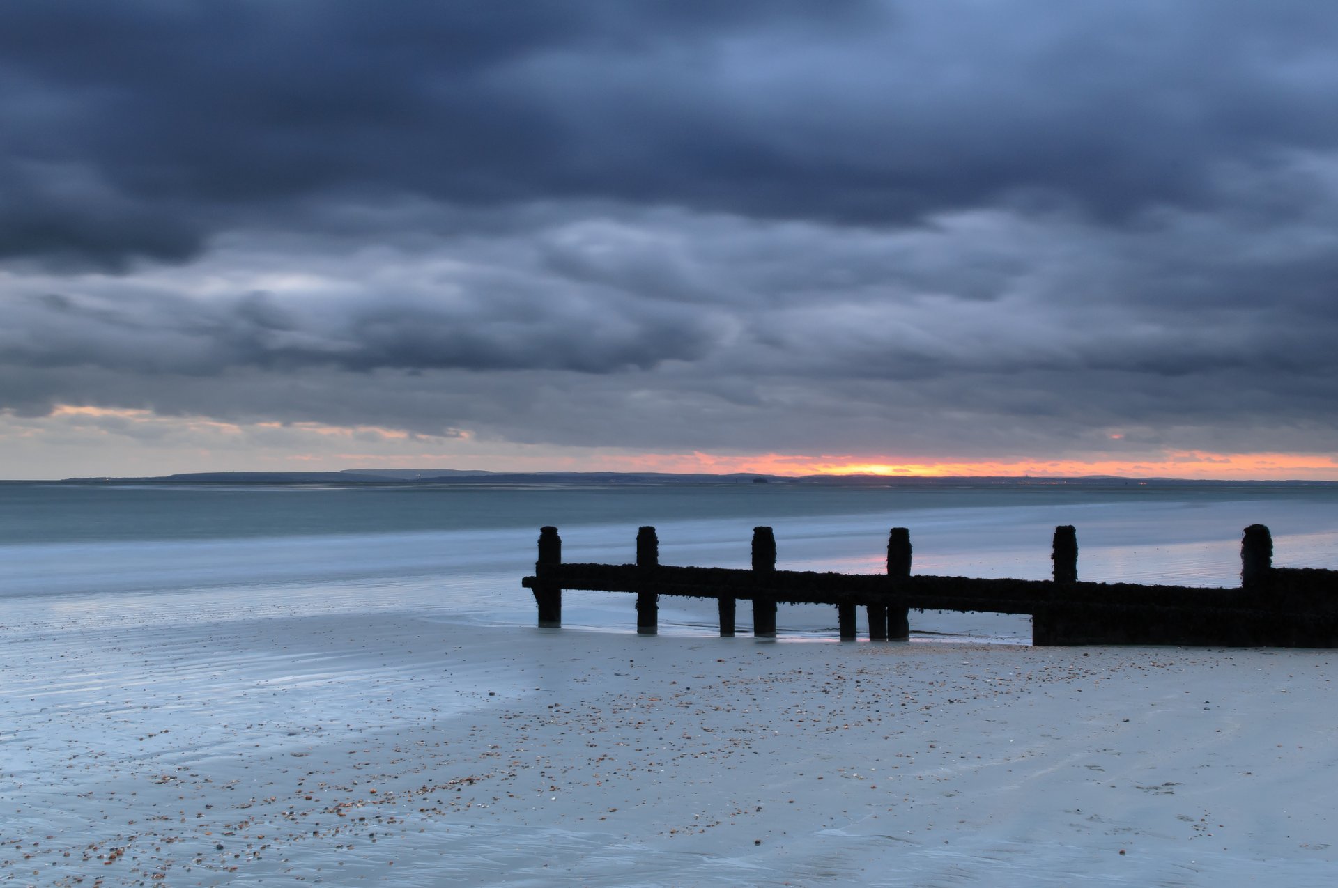 reino unido inglaterra mar costa arena apoyos tarde puesta del sol cielo nubes