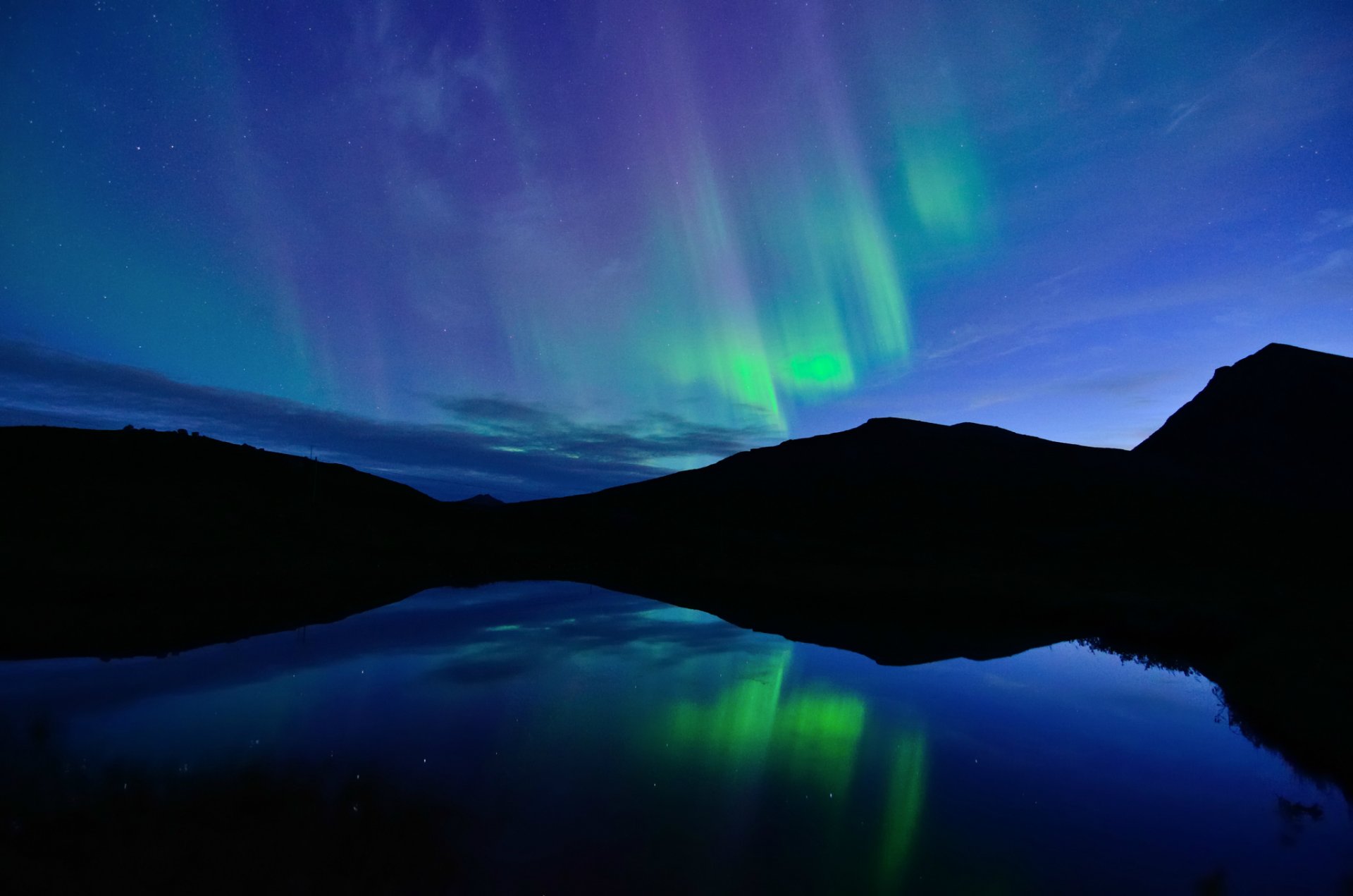 norvège nuit nord aurores boréales bleu ciel nuages lac eau surface réflexion