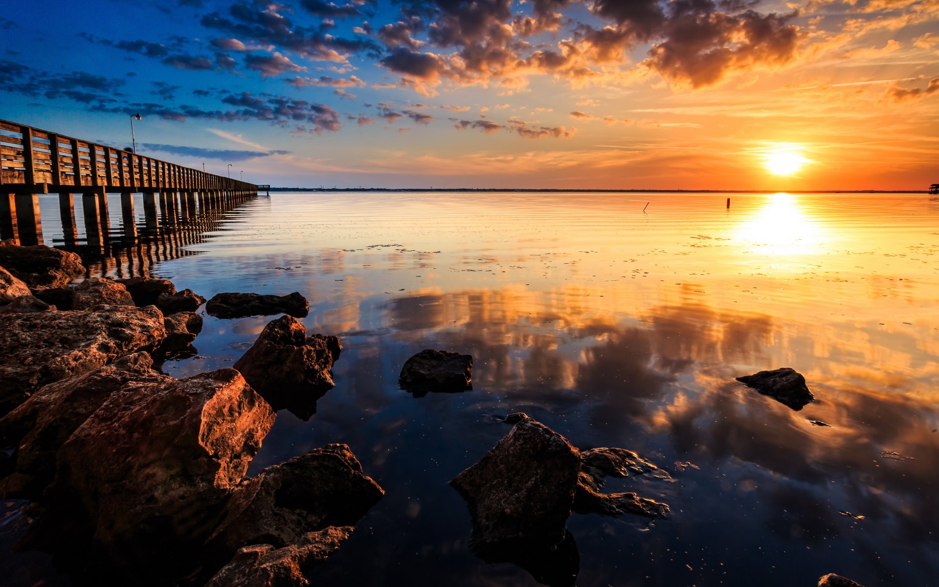 paesaggio natura tramonto sole molo pietre