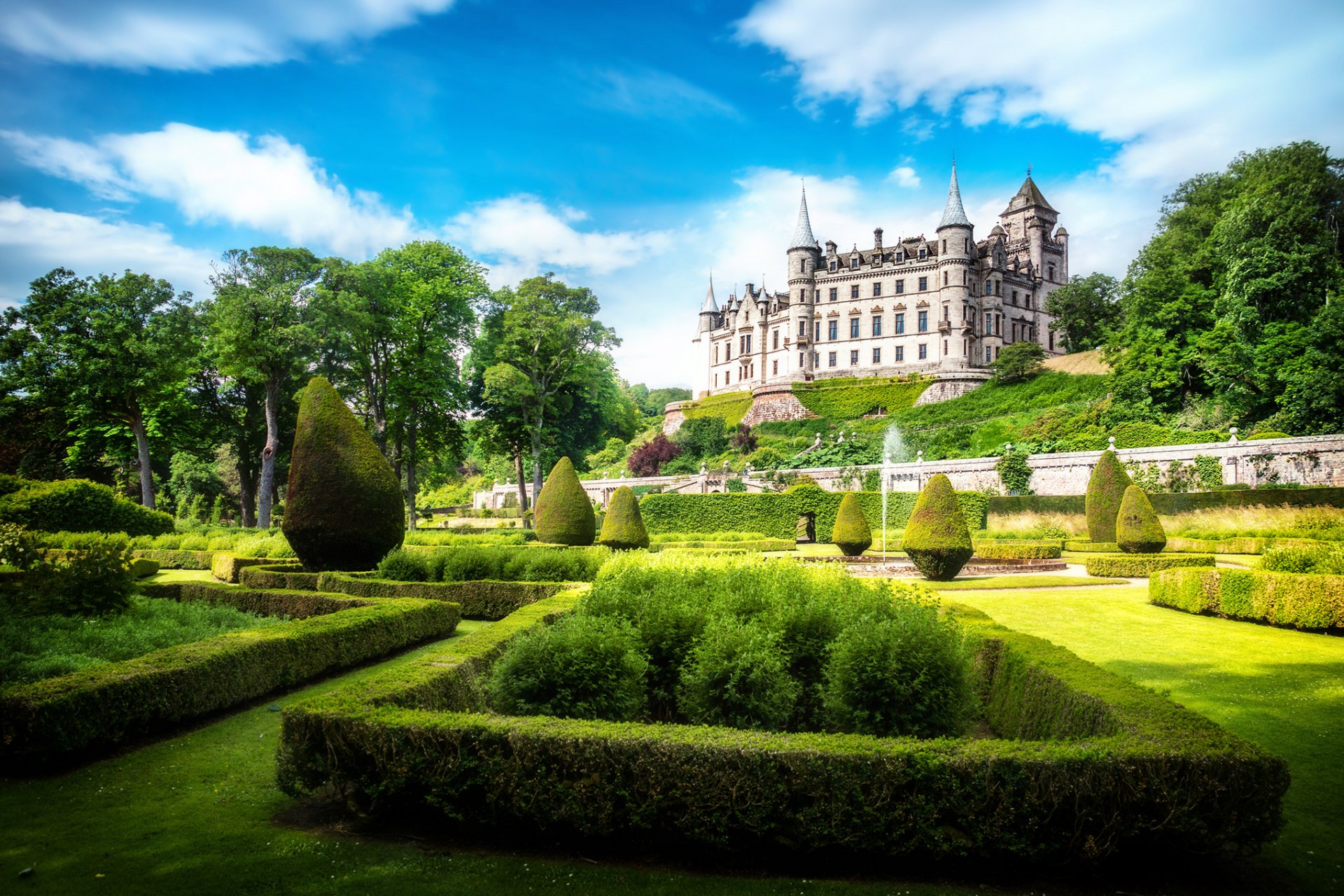 dunrobin castello sutherland scozia alba regno unito castello parco sole luce cielo nuvole verde erba prato cespugli alberi fontana natura paesaggio