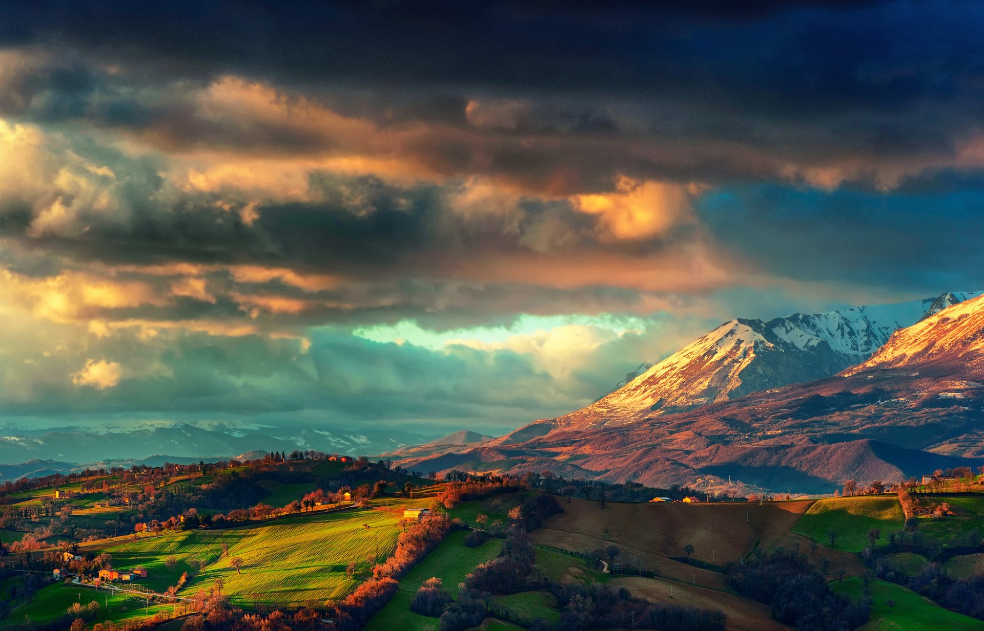 italia appennini montagne catena montuosa dei monti sibillini primavera marzo nuvole di tempesta cielo valle campi case