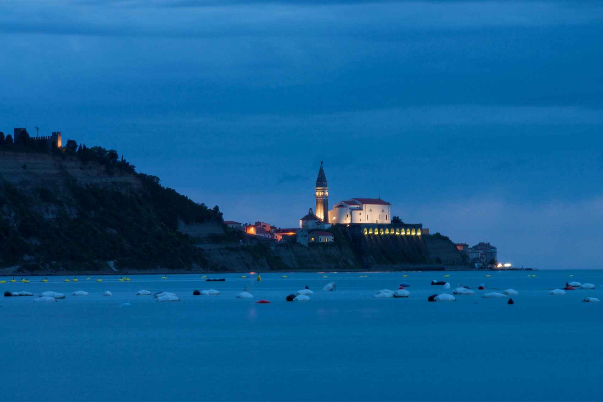 slovenia mare adriatico sera crepuscolo città case chiesa luci illuminazione blu cielo paesaggio