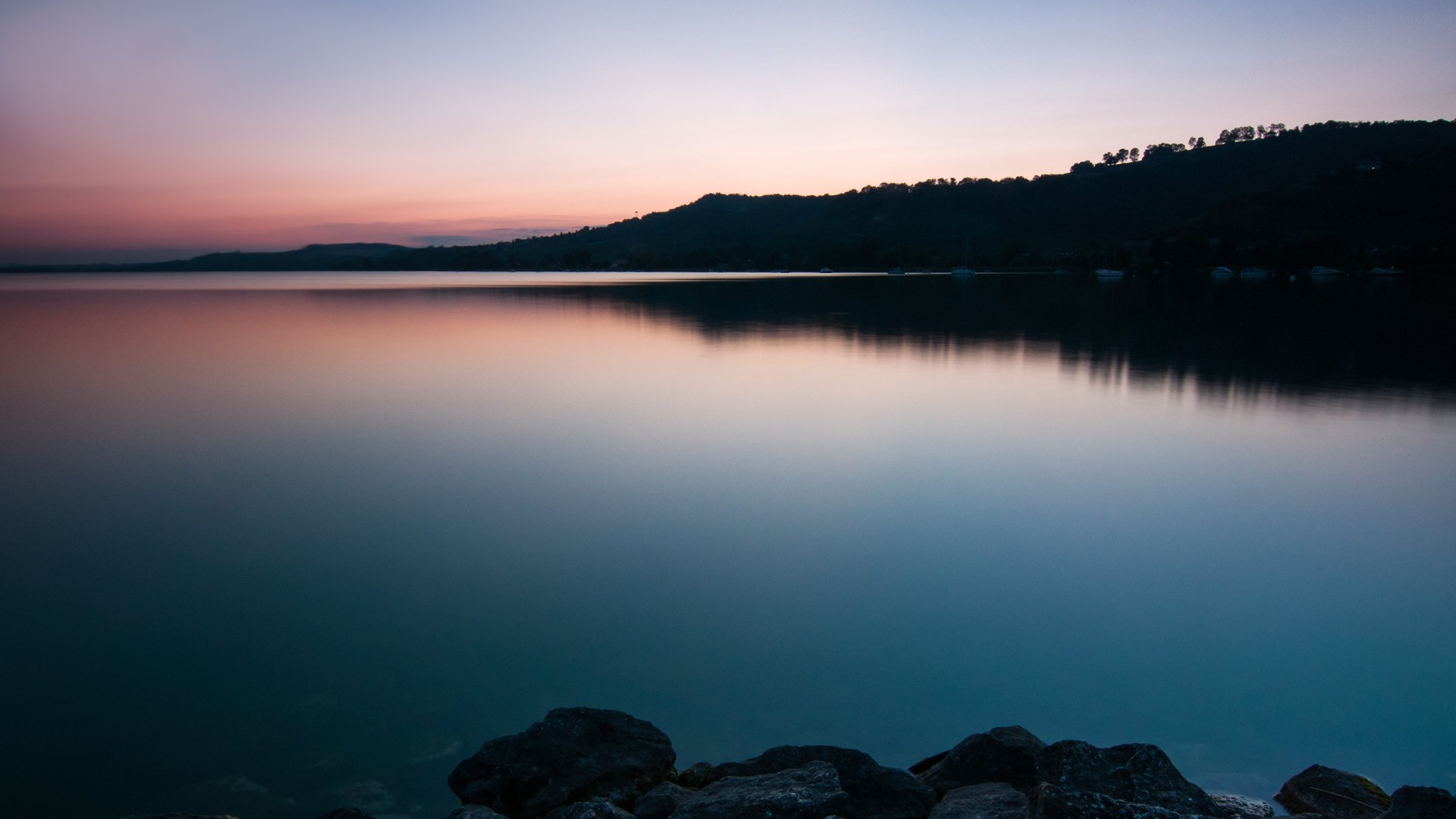 svizzera lago riva rocce acqua superficie liscia alberi sera tramonto cielo