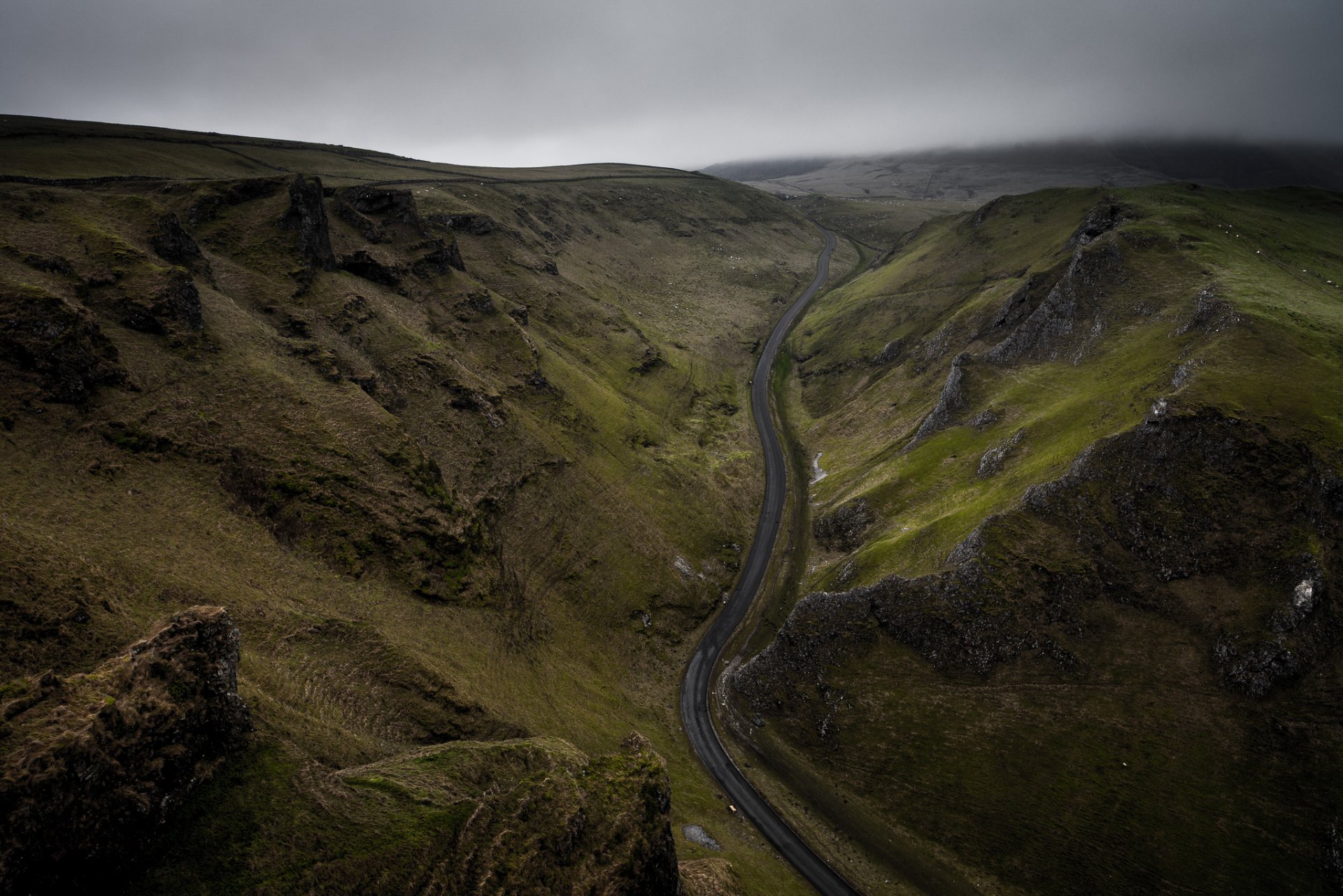 inglaterra reino unido winnats pass carretera colinas rocas hierba verde cielo nubes sombrío mañana duncan fox foto