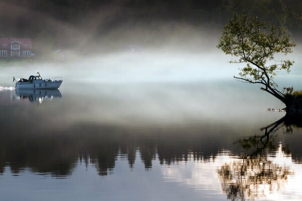 The boat sails through the fog to the pier