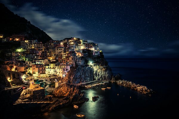 Vista de la Italia nocturna. Luces brillantes de la ciudad nocturna en la costa