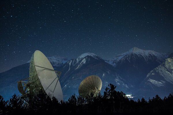 Antenas parabólicas por la noche en las montañas