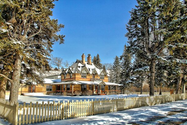 Herrenhaus hinter einem Zaun unter dem Winterhimmel