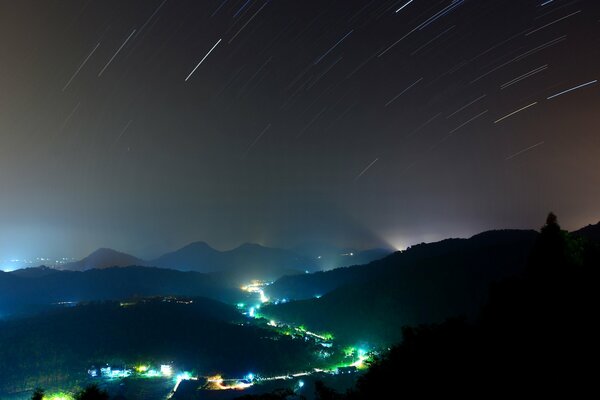 Collines dans la nuit au-dessus de laquelle les étoiles tombent