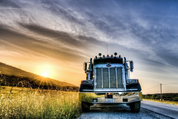 LKW am Straßenrand am Feld bei Sonnenuntergang