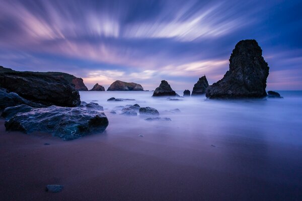 The blue sea and black rocks