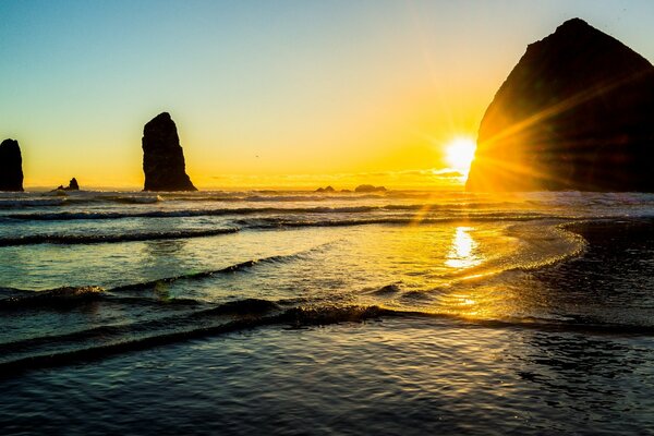 Oszałamiający Zachód słońca nad morzem ze skałami