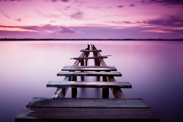 Un viejo muelle al amanecer que se adentra en el mar