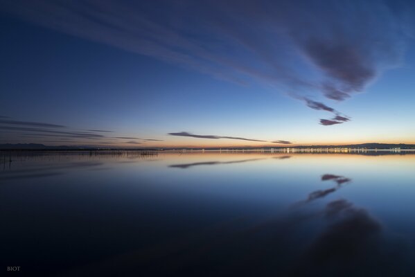 Graue Wolken spiegeln sich im Meer wider