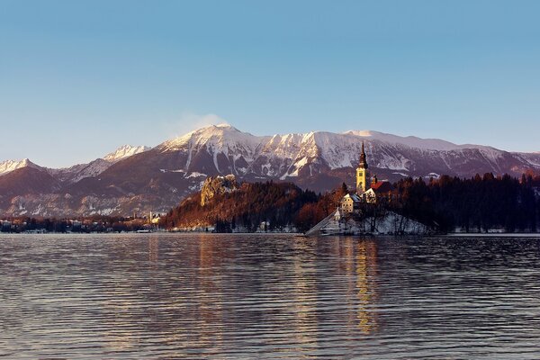 Château entouré de montagnes et de forêt sur le fond de la surface de l eau du lac